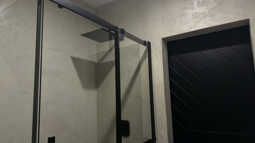 Concrete look microcement shower walls with black fixtures