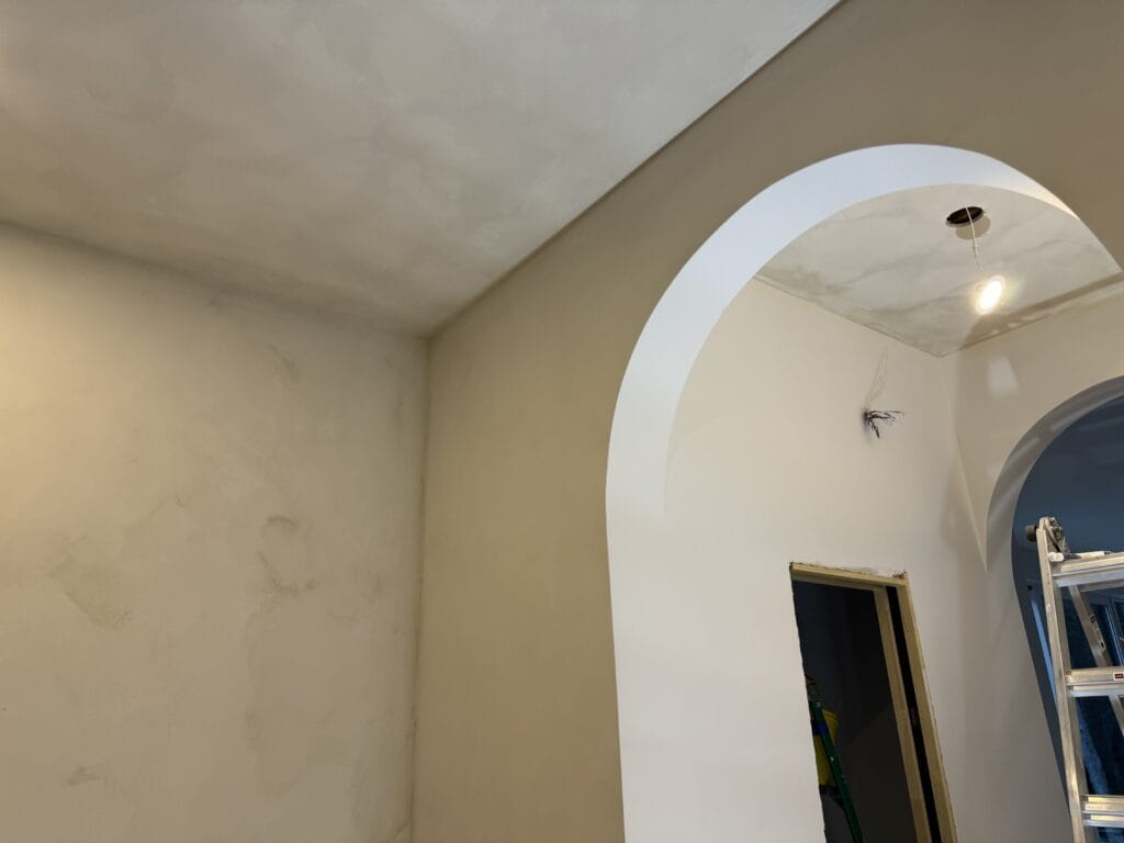 Stone effect plaster walls with an arched opening, Toronto
