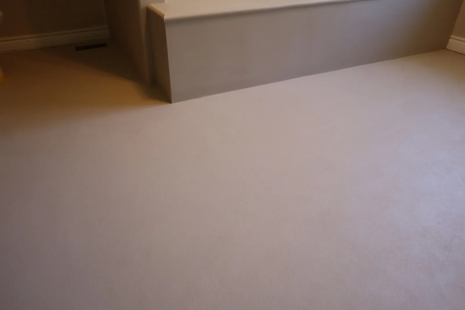 Hand-troweled microcement floor showing soft trowel movement in raking light