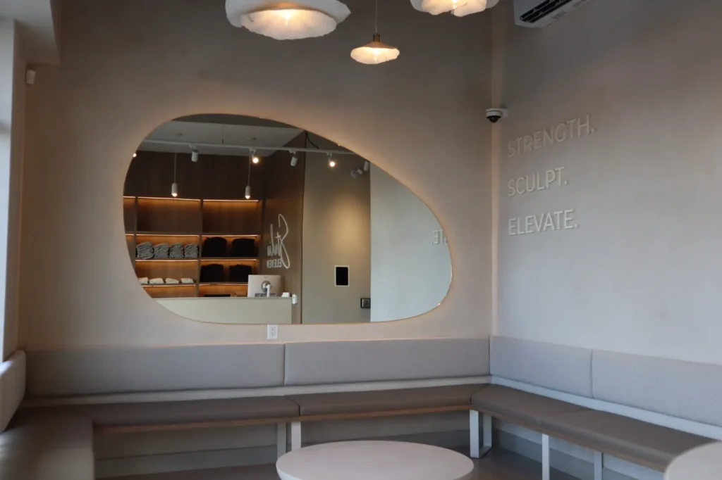 Limewash lounge wall with recessed organic mirror and built-in bench