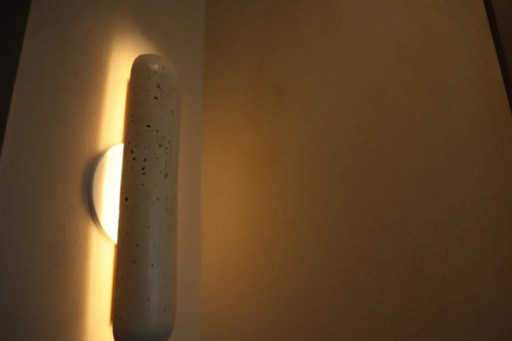 Close-up of limewash texture under a wall sconce