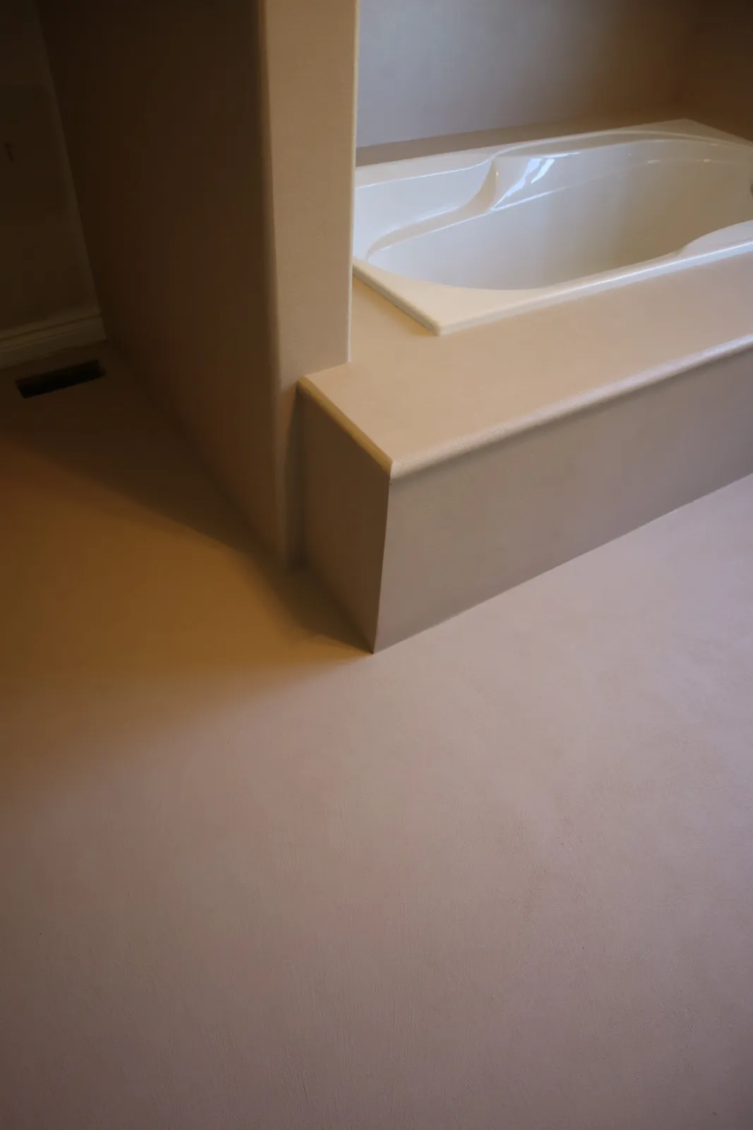 Rounded microcement nose on a tub platform replacing a ceramic bullnose trim