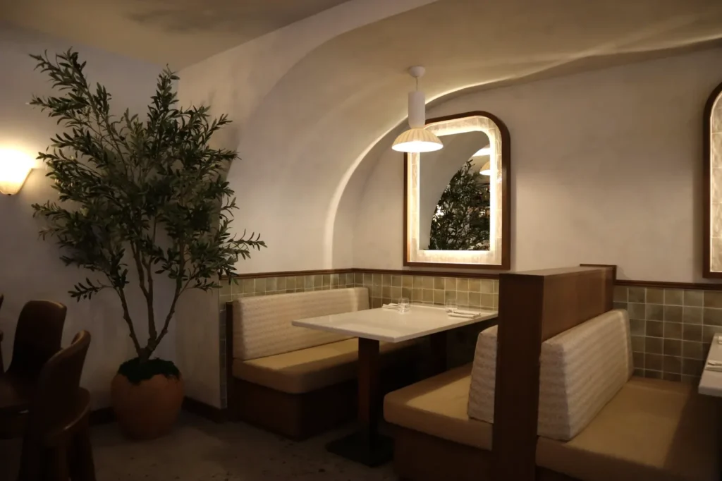 Light two-tone limewash walls and arched cove above banquette seating in a Toronto restaurant